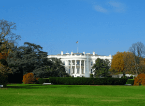 Photo of the White House in Washington with a green lawn and a blue sky
