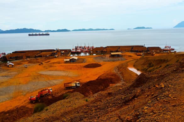 View of nickel ore being loaded off the island of South Sulawesi, Indonesia, featuring ground, trees, sea, sky