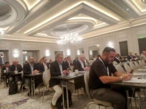 People sitting at conference tables in a modern ballroom hall at the International Minor Metals Conference 2023