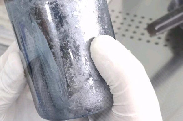 Gloved hand holding a polycrystalline cadmium zirconium telluride ingot for single crystal growth. Image by TuocaiTech
