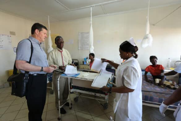 Two male and one female medics pictured examining notes on a maternity ward