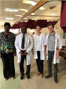 Image of two Zambian and two British doctors standing in a hospital ward