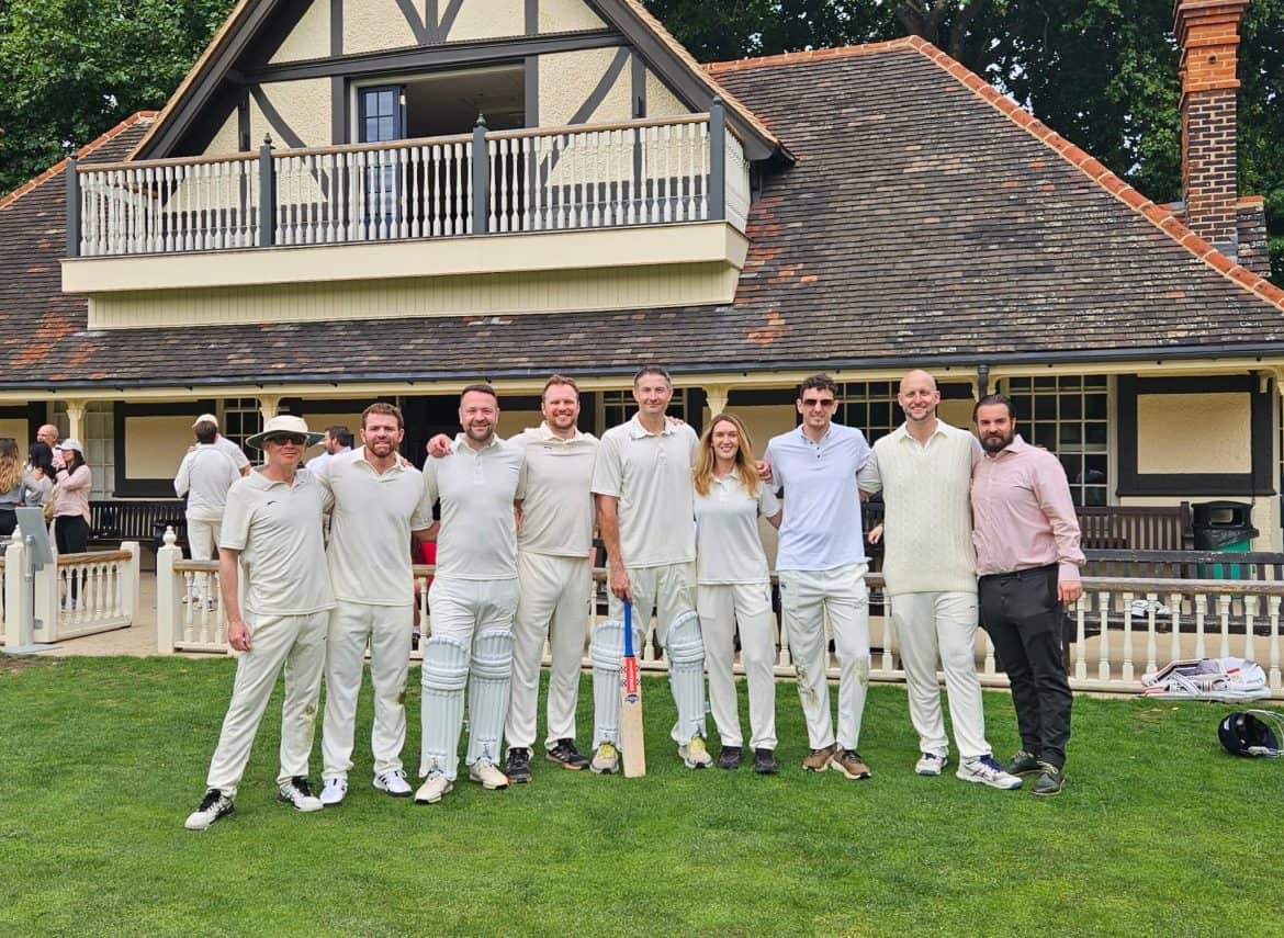 MMTA cricket team standing on the edge of a cricket field