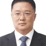 Dr Jinghui Wu, a dark haired man with wire rimmed glasses and a blue tie