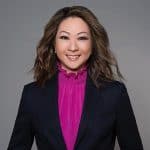 Jessica Fung, a woman with long brown hair wearing a magenta top and a navy blazer