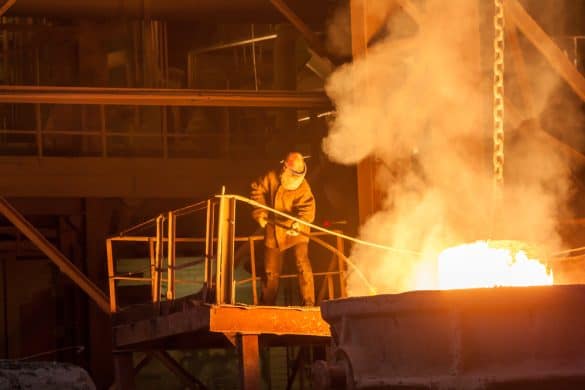 Worker at a ferroalloy plant working over an open ark furnace