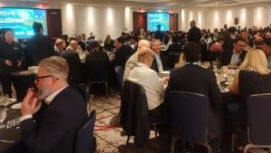 People sitting at round tables at a formal dinner.